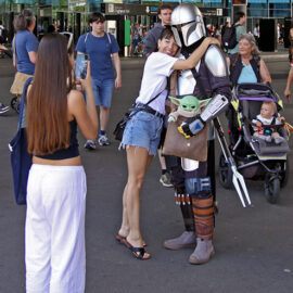 A woman hugging Din Djarin (Mandalorian) carrying Din Grogu (Baby Yoga) in his bag, at Fantasy Basel, the Swiss Comic Con; photo by Ivan Kralj.