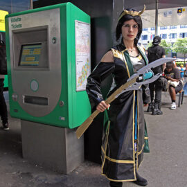 Cosplayer Gina Zhenya dressed as Loki from "Loki: Agent of Asgard" Marvel Comics series, standing by the public transport ticket machine, at Fantasy Basel, the Swiss Comic Con; photo by Ivan Kralj.