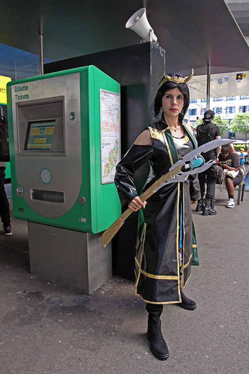 Cosplayer Gina Zhenya dressed as Loki from "Loki: Agent of Asgard" Marvel Comics series, standing by the public transport ticket machine, at Fantasy Basel, the Swiss Comic Con; photo by Ivan Kralj.