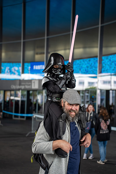 A dad carrying a son dressed up as a mini Darth Vader from the Star Wars, shot in front of the Messe Basel, the venue of Fantasy Basel, the Swiss Comic Con.