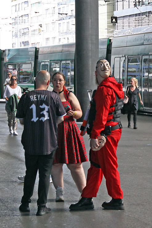 Cosplayers standing outside Messe Basel, among them a visitor dressed up as a robber in Netflix's "Money Heist" or "La casa de papel" heist crime drama TV series, at Fantasy Basel, the Swiss Comic Con; photo by Ivan Kralj.