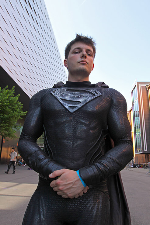 A cosplayer in black Superman costume posing in front of Messe Basel, the venue of Fantasy Basel, the Swiss Comic Con; photo by Ivan Kralj.