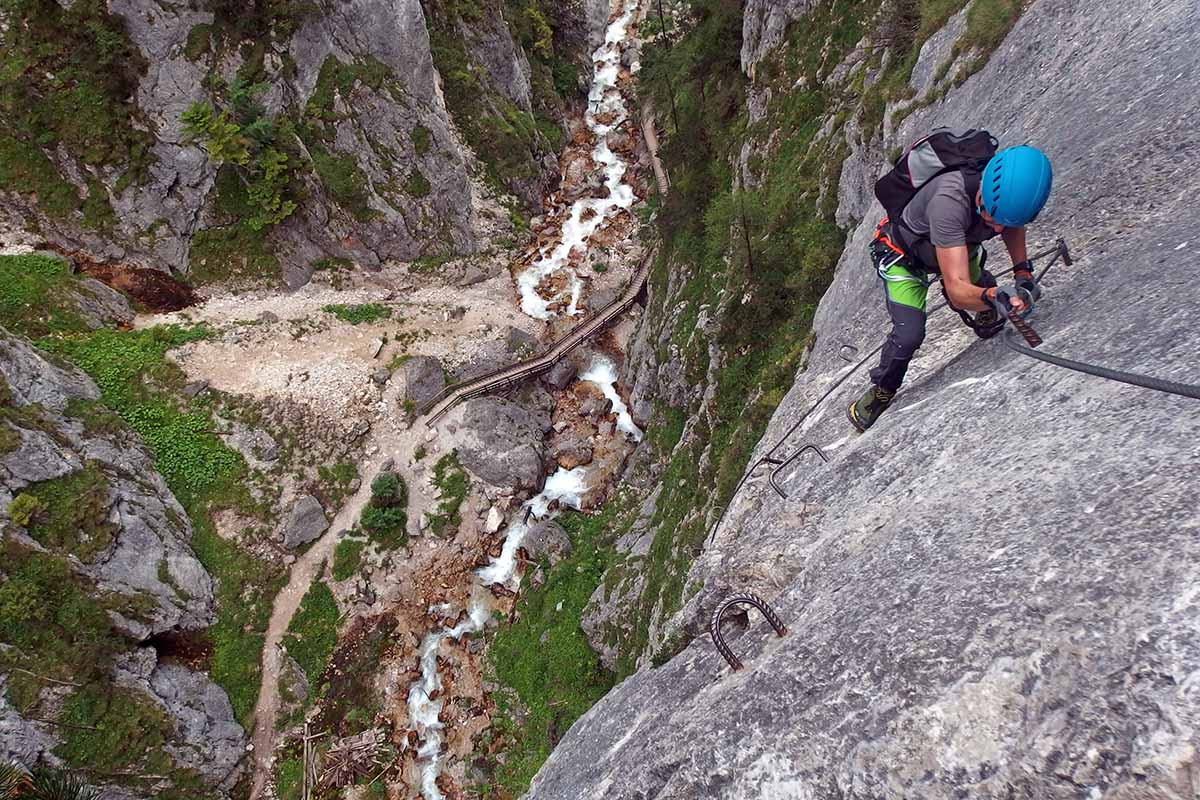Climber climbing Rosina Via Ferrata in Austria, above a waterfall; photo by Maja Kochanowska / Unsplash.