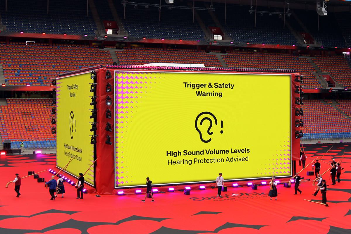 High sound volume level warning displayed on the screens of the cube stage at Arena Plus Eurovision pre-show at St. Jakob-Park stadium in Basel, Switzerland; photo by Ivan Kralj.