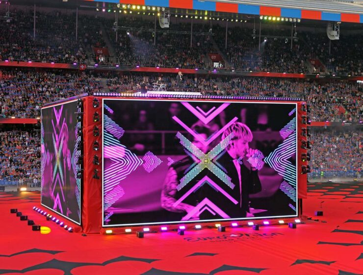 A giant screen-cube displaying Croatian musician Baby Lasagna performing at St. Jakob-Park stadium in Basel, Switzerland, during the Arena Plus Eurovision pre-show; photo by Ivan Kralj.