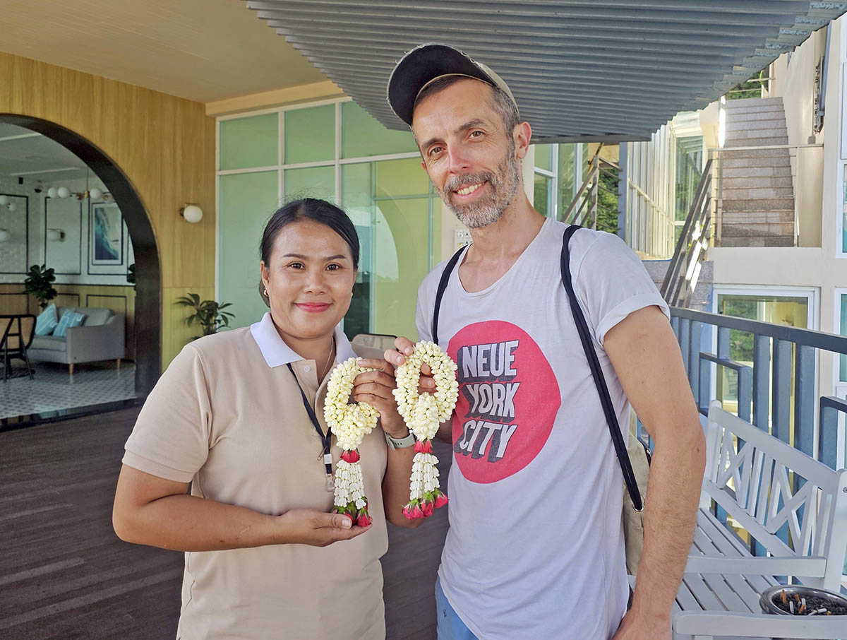 Flower garland workshop instructor Nam and travel blogger Ivan Kralj posing with their creations at the Hilltop Wellness Resort in Phuket, Thailand; photo by Ivan Kralj.