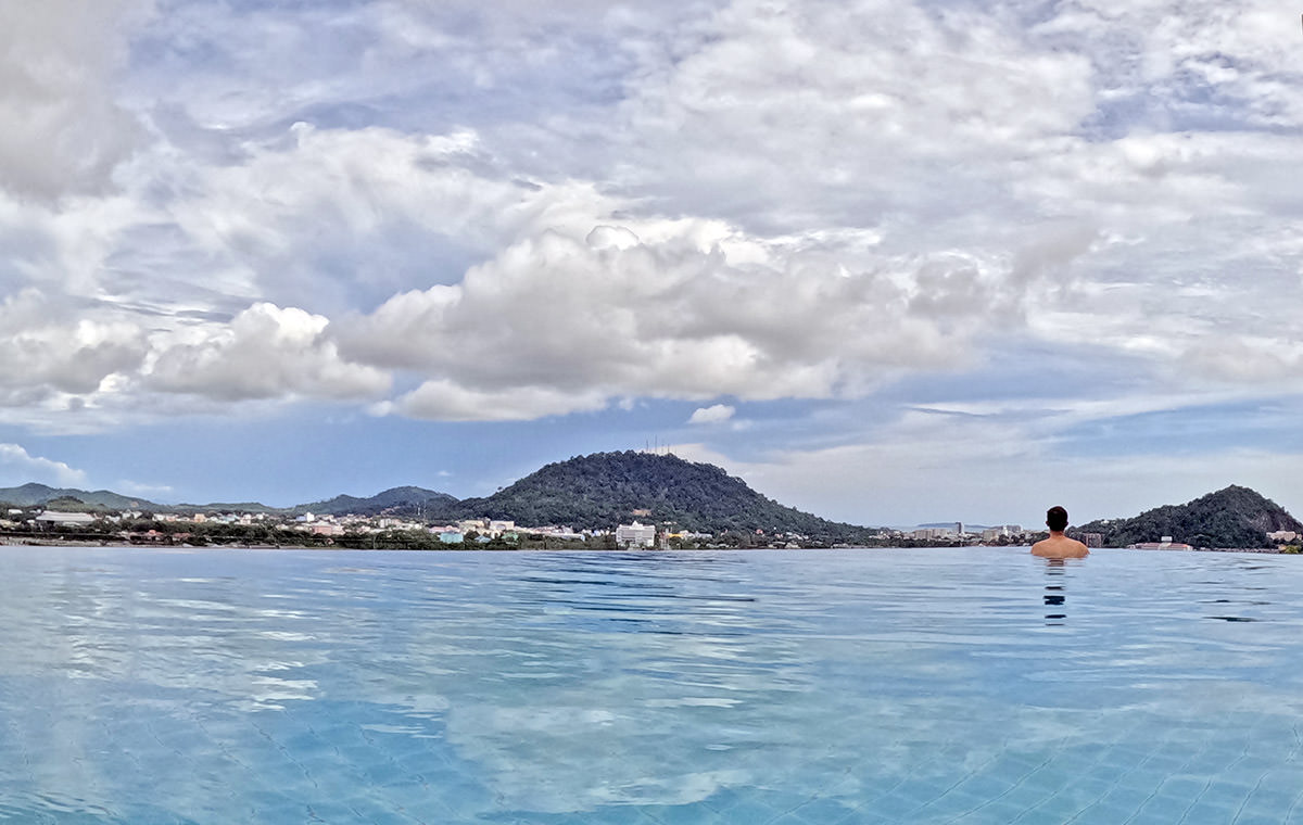Travel blogger Ivan Kralj at the edge of the infinity pool shot from behind, at Hilltop Wellness Resort in Phuket, Thailand; photo by Ivan Kralj.