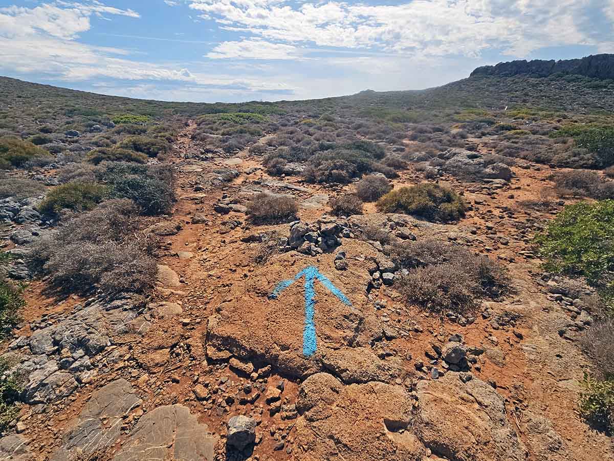 Blue arrow marking the right path through bushy landscape towards the Green Lake or Prasini Limni on Kythira Island, Greece; photo by Ivan Kralj.