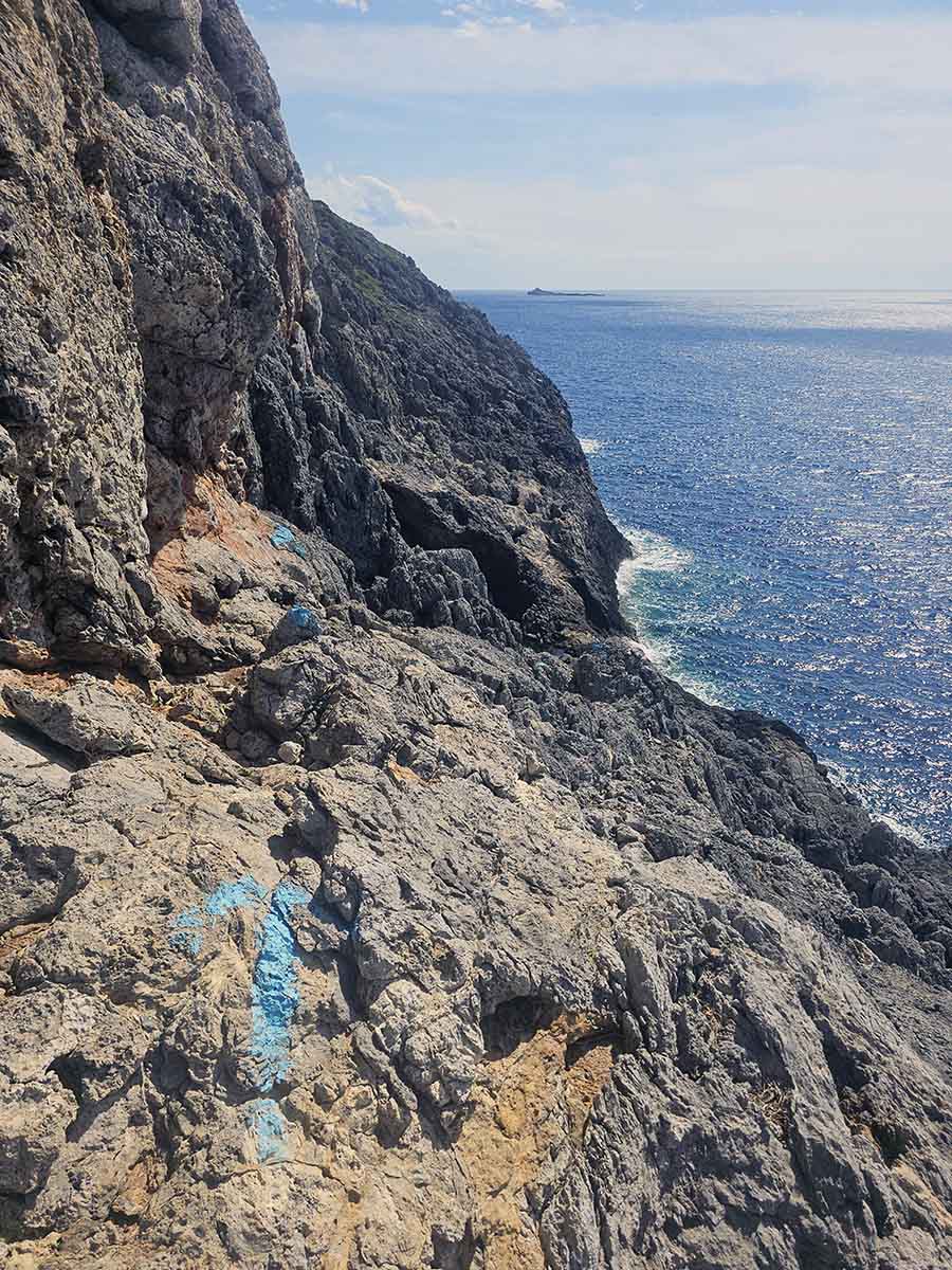 Blue arrow sprayed on coastal rocks on Kythira Island, Greece, to mark the direction toward the Green Lake, a heart-shaped lake on Aphrodite's island; photo by Ivan Kralj.