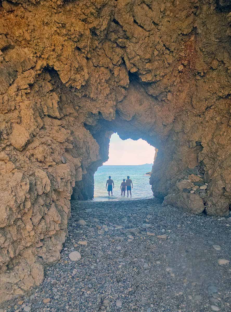People standing in the shallows of the cave-like entrance into the sea at Kaladi Beach, Kythira Island, Greece; photo by Ivan Kralj.