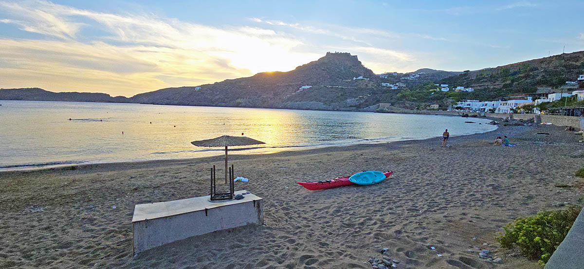 Kayaks resting on Kapsali Beach in Kythira, with Kythira Castle in the background during sunset; photo by Nikos Samartzis.