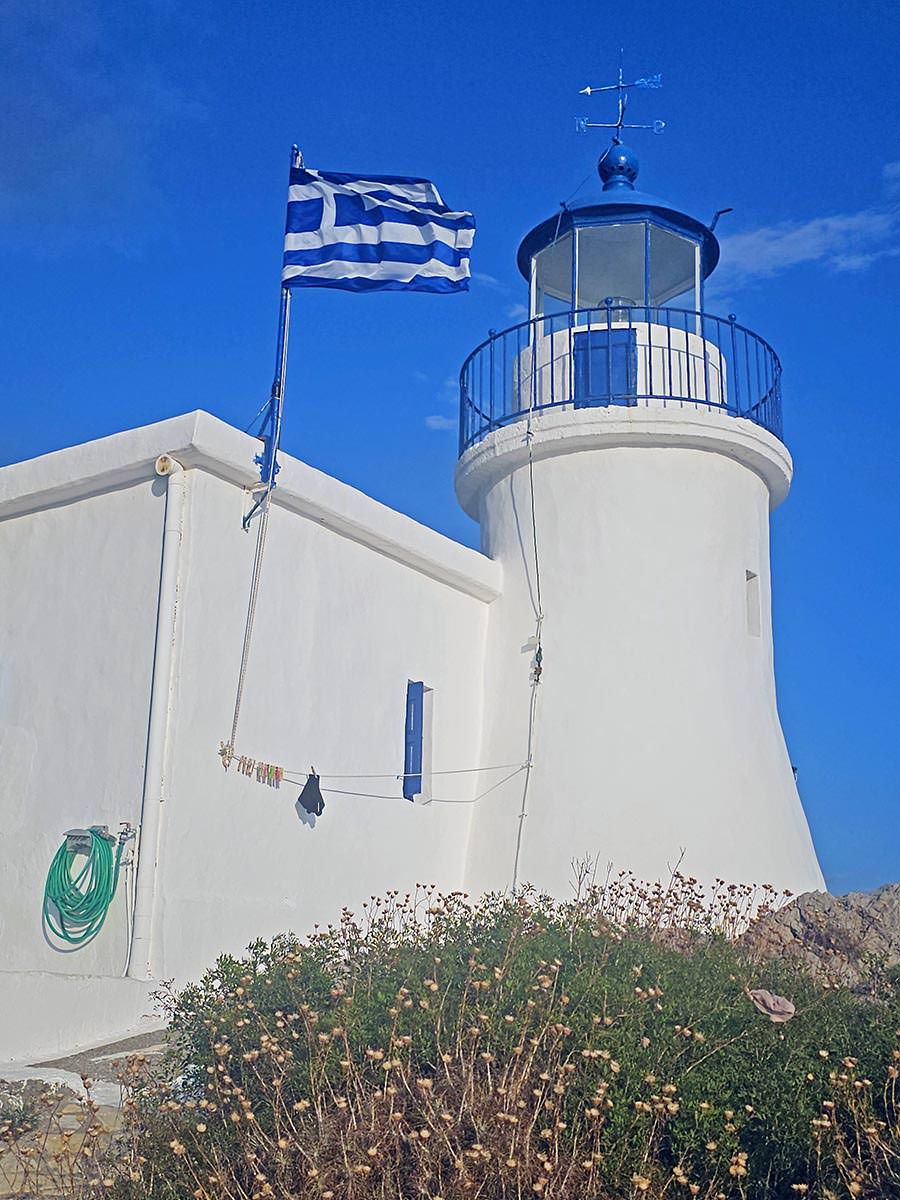 Swimwear drying on the rope at Kapsali Lighthouse, with Greek flag fluttering in the wind, on Kythira Island, Greece; photo by Ivan Kralj.