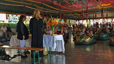 Church mass service at Autoscooter bumper cars attraction at Kaserne, Basel, Switzerland, during the Basel Autumn Fair; copyright Basler Herbstmesse.