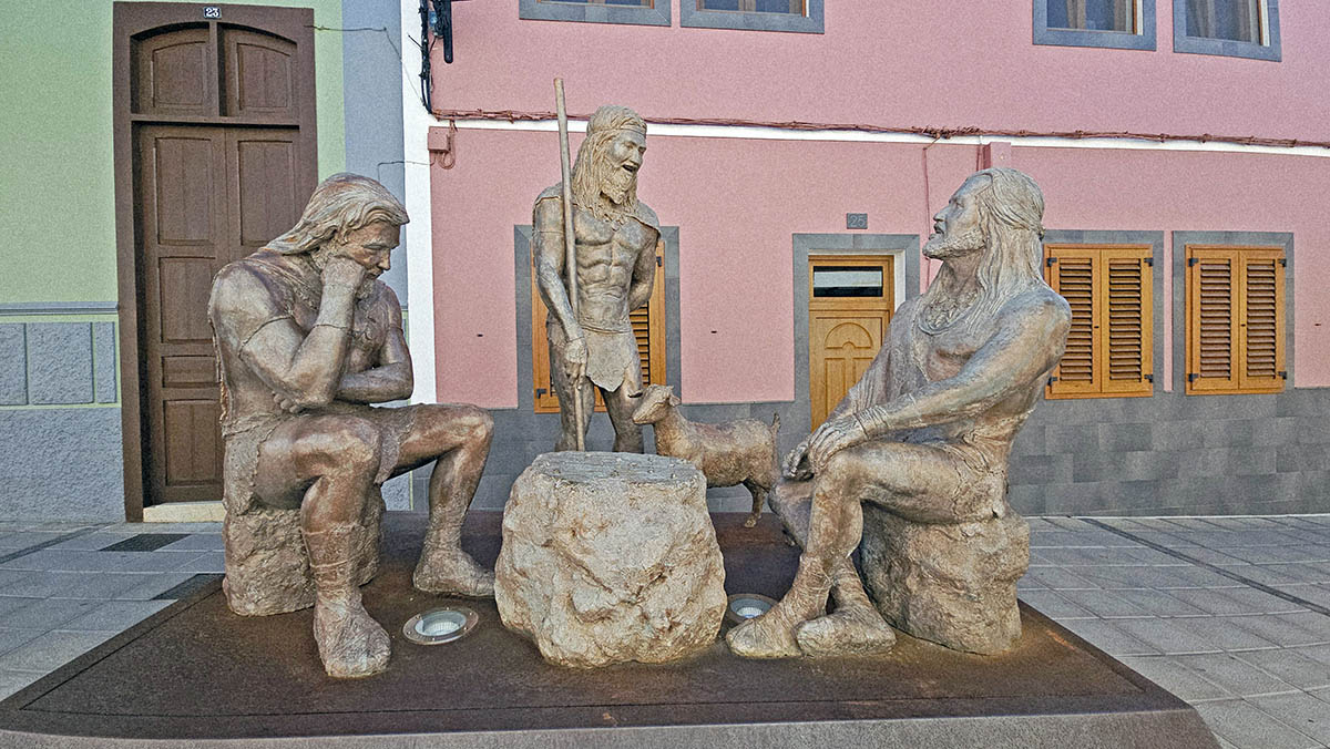 The sculpture representing daily lives of Guaires, the indigenous Canarian leaders, warrior-captains from the pre‑Hispanic kingdom of Agáldar, in Calle Guaires, Gáldar, Gran Canaria, Spain; photo by Ivan Kralj. 