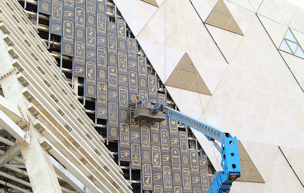 Construction workers on a crane setting up panels on the facade of the Grand Egyptian Museum under construction in Giza 2019; photo by Djehouty.