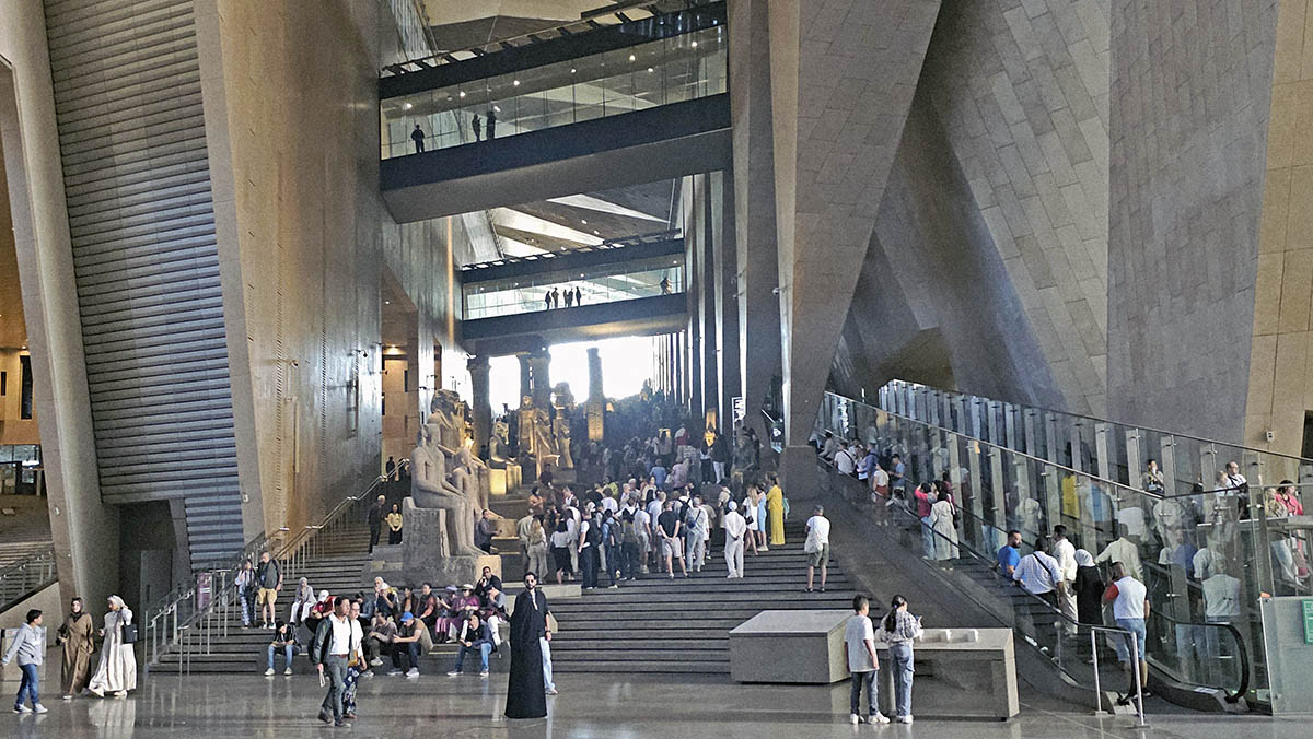 Grand Stairs of the Grand Egyptian Museum in Giza, Egypt, filled with exhibited artifacts and visitors; photo by Ivan Kralj.