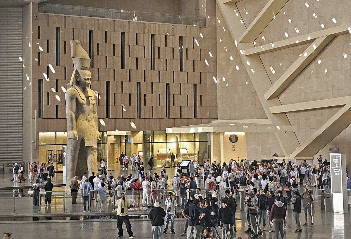 The colossal statue of Ramesses II, the third king of the 19th dynasty of ancient Egypt, surrounded by visitors of the Grand Egyptian Museum; photo by Ivan Kralj. 