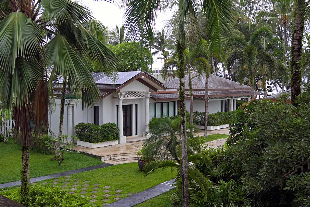 One of Anda Mani Khaolak Beachfront Villas in Thailand - exterior, surrounded by tropical palms, ornamental trees, and manicured lawns; photo by Ivan Kralj.