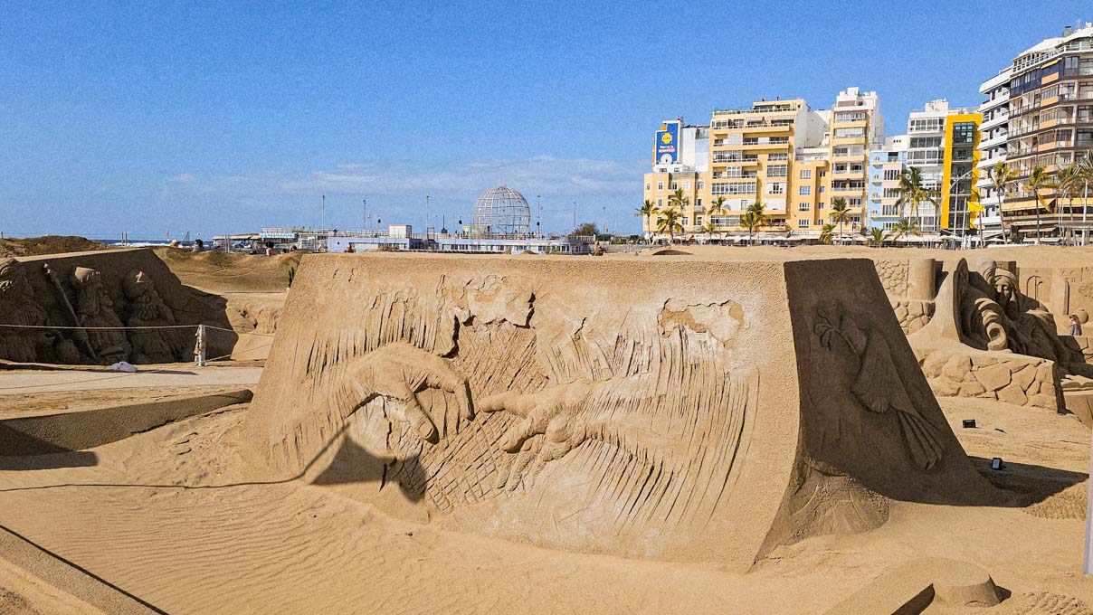 A monumental sand sculpture representing the detail of almost-touching hands of Adam and God in Michelangelo's "The Creation of Adam", part of Belén de Arena at Playa de las Canteras, the world's largest sand nativity scene, located in Las Palmas, Gran Canaria, Spain; photo by Ivan Kralj.