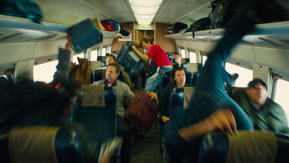 A chaotic cabin of a train during a crash, with blurred bodies and flying debris; AI image by Ivan Kralj / Reve.