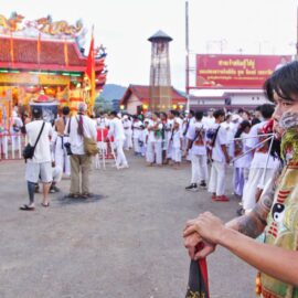 Ma song participant of the Phuket Vegetarian Festival, his cheeks pierced by spikes, standing in front of the Lim Hu Tai Su Shrine; photo by Ivan Kralj.