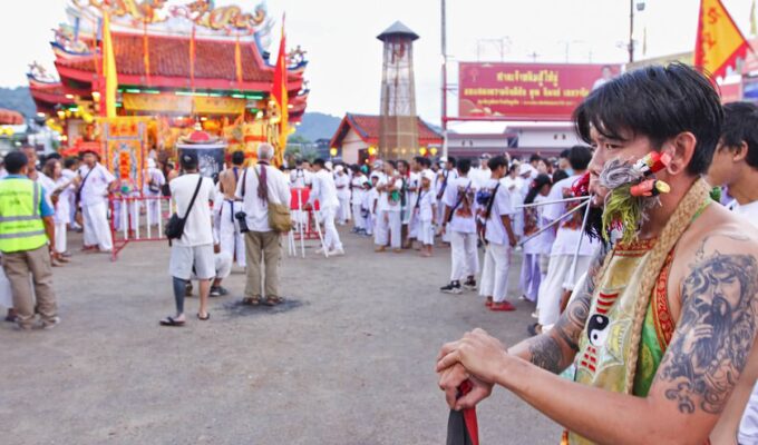 Ma song participant of the Phuket Vegetarian Festival, his cheeks pierced by spikes, standing in front of the Lim Hu Tai Su Shrine; photo by Ivan Kralj.