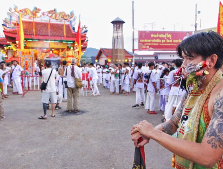 Ma song participant of the Phuket Vegetarian Festival, his cheeks pierced by spikes, standing in front of the Lim Hu Tai Su Shrine; photo by Ivan Kralj.
