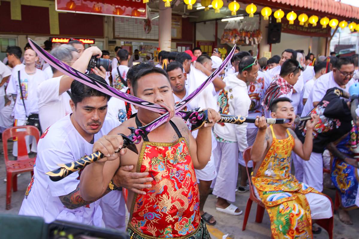 Ma song participants of the Phuket Vegetarian Festival, their cheeks pierced by sabers, awaiting the start of the procession from the Lim Hu Tai Su Shrine; photo by Ivan Kralj.