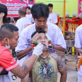 Ma song participant of the Phuket Vegetarian Festival in trance, eyes rolled back, as his cheeks get pierced with spikes, at the Lim Hu Tai Su Shrine; photo by Ivan Kralj.