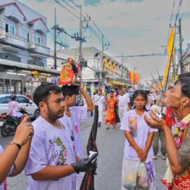 Ma song participant of the Phuket Vegetarian Festival, his face heavily pierced with spikes, standing by the road during the procession of the Lim Hu Tai Su Shrine, Thailand; photo by Ivan Kralj.