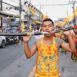 Ma song participant of the Phuket Vegetarian Festival, his face pierced with a sword, walking in the procession from the Lim Hu Tai Su Shrine, Thailand; photo by Ivan Kralj.