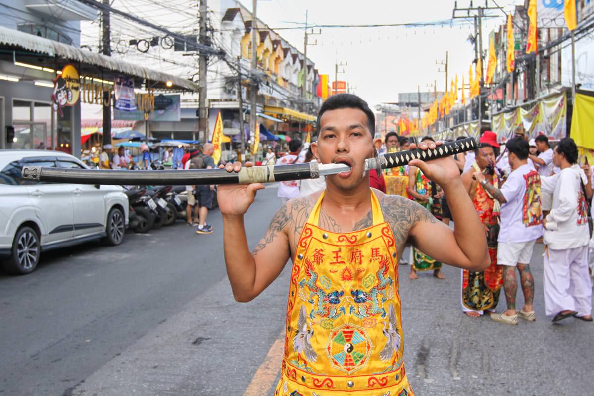 Ma song participant of the Phuket Vegetarian Festival, his face pierced with a sword, walking in the procession from the Lim Hu Tai Su Shrine, Thailand; photo by Ivan Kralj.
