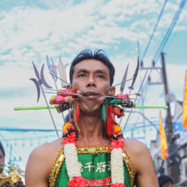 Ma song participant of the Phuket Vegetarian Festival, his face pierced with spikes, walking in the procession from the Lim Hu Tai Su Shrine, Thailand; photo by Ivan Kralj.