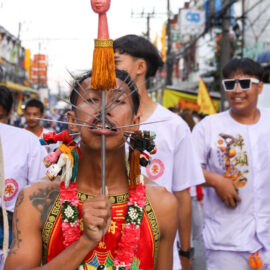 Ma song participant of the Phuket Vegetarian Festival, his face heavily pierced with spikes, walking in the procession from the Lim Hu Tai Su Shrine, Thailand; photo by Ivan Kralj.