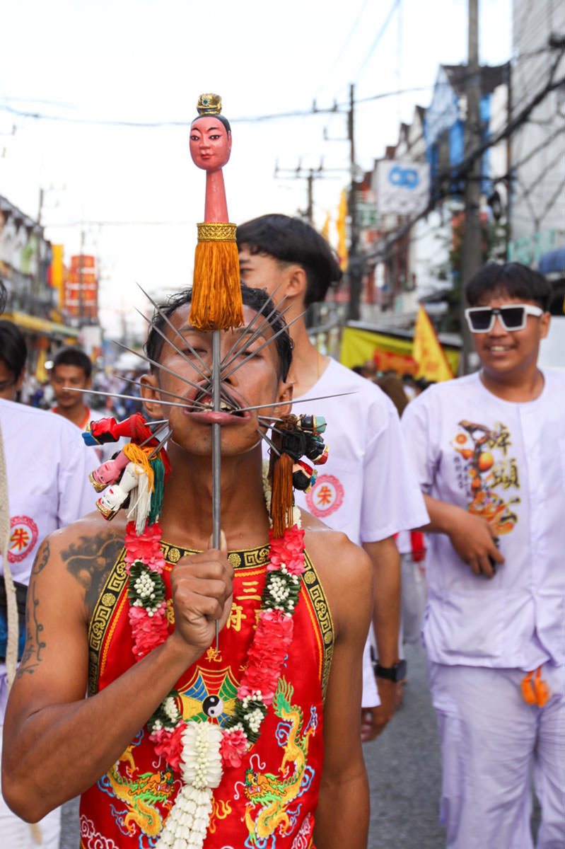 Ma song participant of the Phuket Vegetarian Festival, his face heavily pierced with spikes, walking in the procession from the Lim Hu Tai Su Shrine, Thailand; photo by Ivan Kralj.