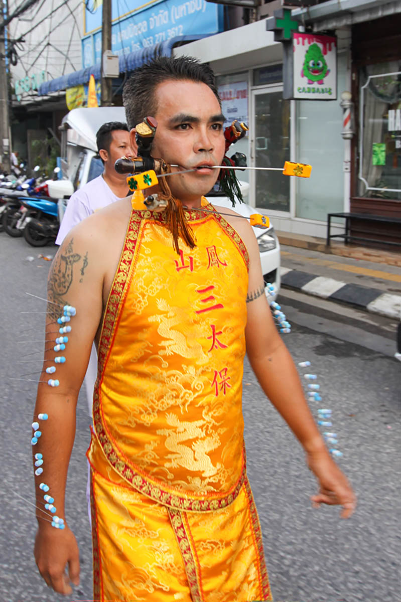 Ma song participant of the Phuket Vegetarian Festival, his face pierced with spikes and arms with needles, walking in the procession from the Lim Hu Tai Su Shrine, Thailand; photo by Ivan Kralj.