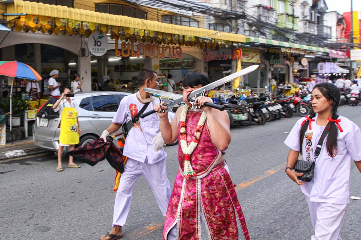 Ma song participant of the Phuket Vegetarian Festival, his face pierced with swords, walking in the procession from the Lim Hu Tai Su Shrine, Thailand; photo by Ivan Kralj.