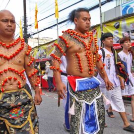 Ma song participants of the Phuket Vegetarian Festival, their bodies pierced with miniature Chinese lanterns in a decorative pattern, walking in the procession from the Lim Hu Tai Su Shrine, Thailand; photo by Ivan Kralj.