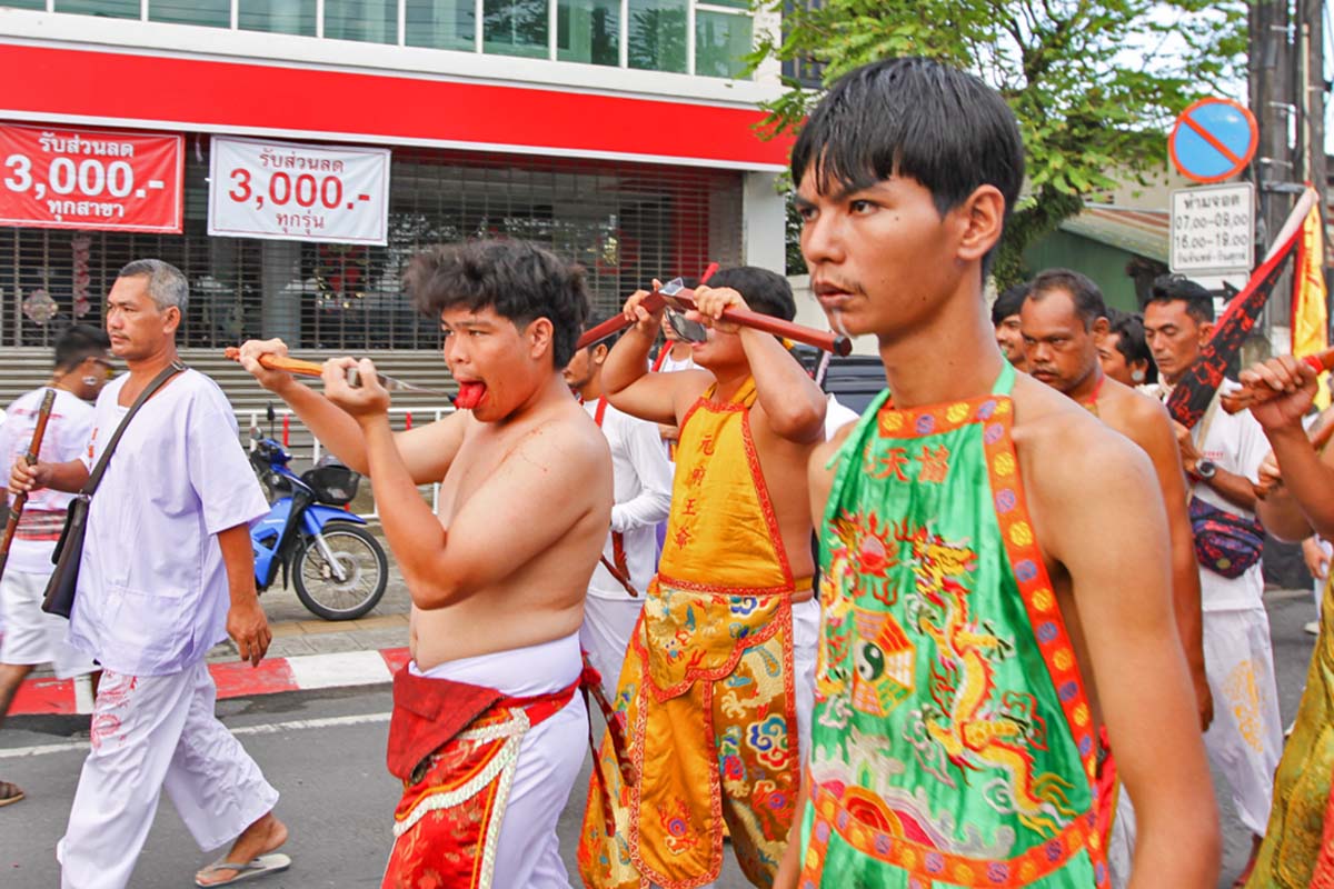 Ma song participants of the Phuket Vegetarian Festival, walking in the procession from the Lim Hu Tai Su Shrine while cutting their tongues with axes, Thailand; photo by Ivan Kralj.