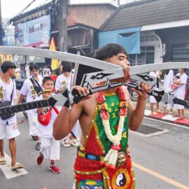 Ma song participant of the Phuket Vegetarian Festival, his face pierced with sabers, walking in the procession from the Lim Hu Tai Su Shrine, Thailand; photo by Ivan Kralj.