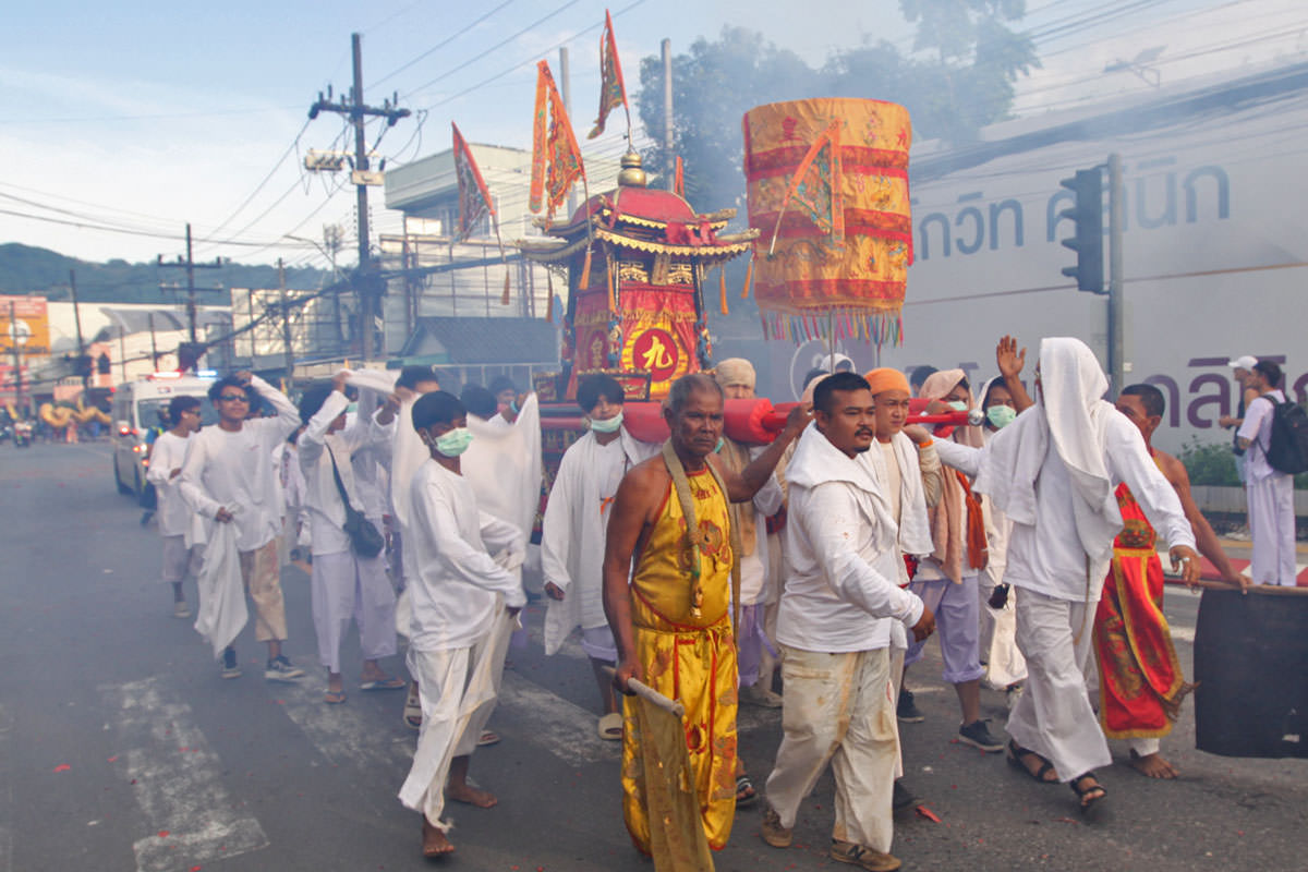 Participants of the Phuket Vegetarian Festival walking in the procession from the Lim Hu Tai Su Shrine, Thailand, while carrying a palanquin, a ceremonial sedan chair of the gods; photo by Ivan Kralj.