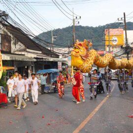 The performers maneuvering the ceremonial dragon in the street of Phuket, Thailand, during the Nine Emperor Gods Festival procession from the Lim Hu Tai Su Shrine; photo by Ivan Kralj.