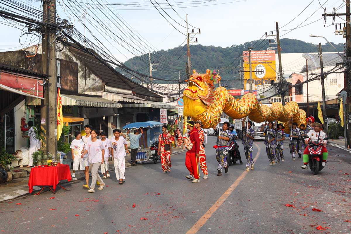 The performers maneuvering the ceremonial dragon in the street of Phuket, Thailand, during the Nine Emperor Gods Festival procession from the Lim Hu Tai Su Shrine; photo by Ivan Kralj.