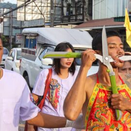 Ma song participant of the Phuket Vegetarian Festival, his face pierced with large secatures or pruning shears, walking in the procession from the Lim Hu Tai Su Shrine, Thailand; photo by Ivan Kralj.