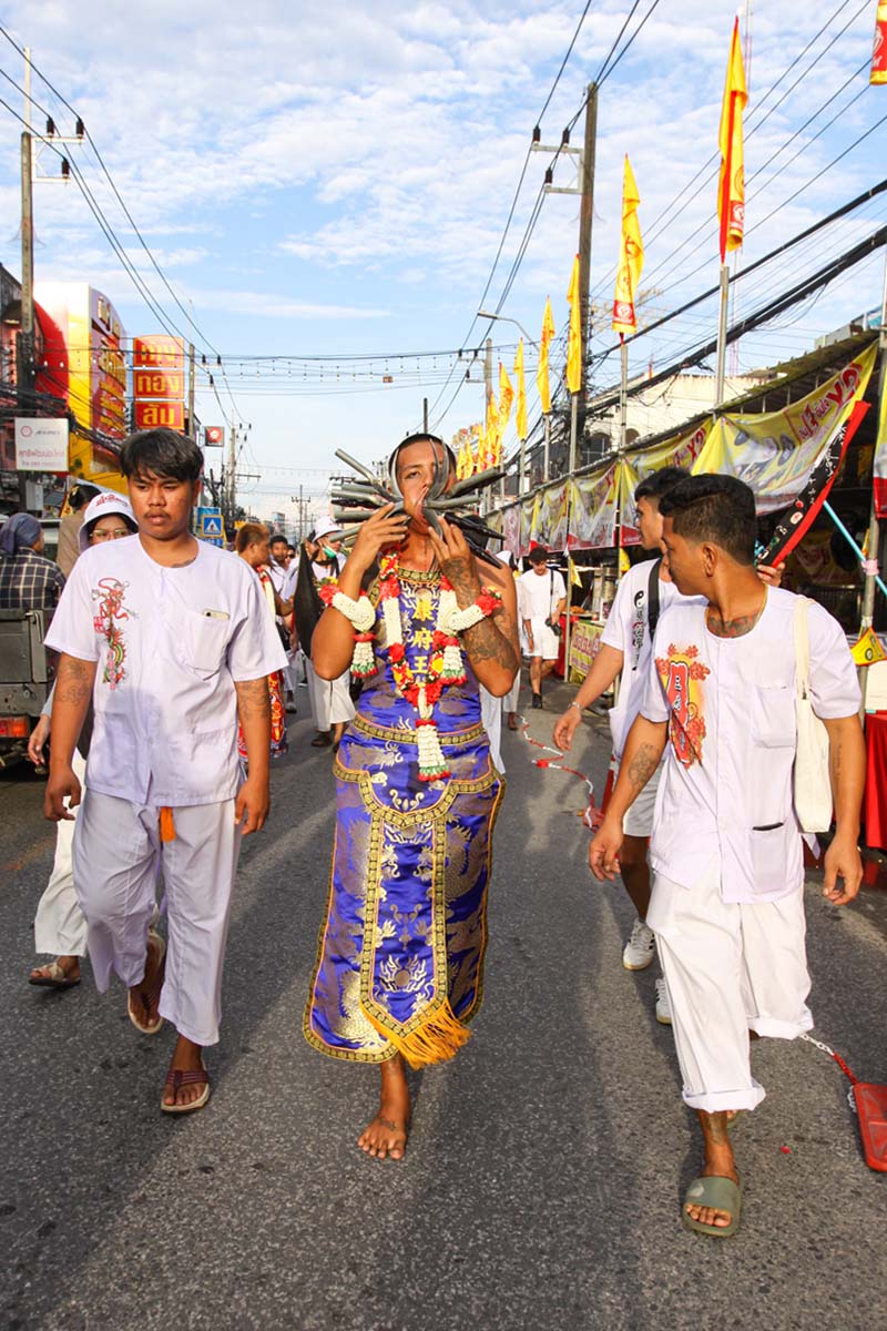 Ma song, spirit medium of the Phuket Vegetarian Festival, his face pierced with sickles, walking in the procession from the Lim Hu Tai Su Shrine, Thailand; photo by Ivan Kralj.