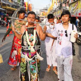 Ma song, one of the spirit mediums at the Phuket Vegetarian Festival, his face pierced with an anchor, walking in the procession from the Lim Hu Tai Su Shrine, Thailand; photo by Ivan Kralj.