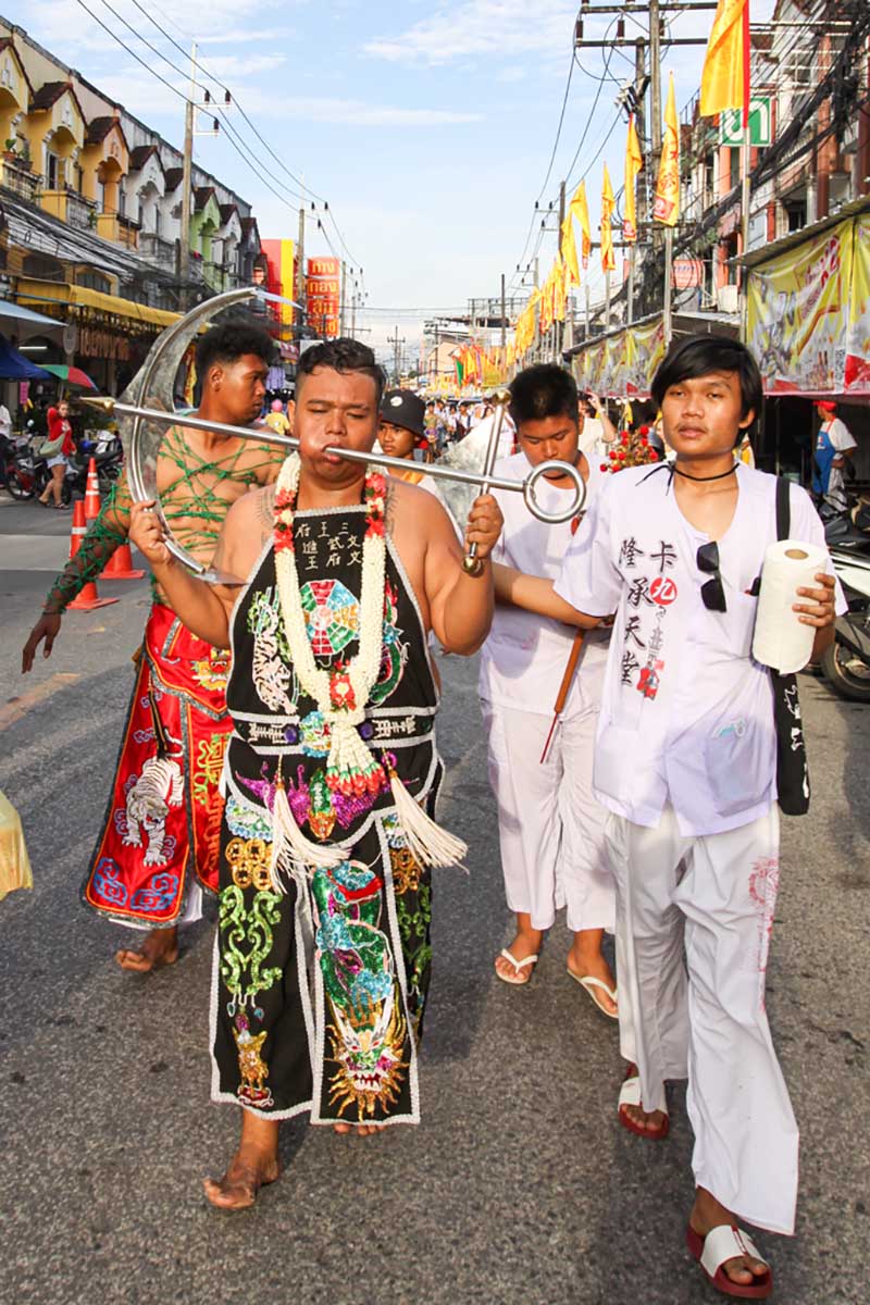Ma song, one of the spirit mediums at the Phuket Vegetarian Festival, his face pierced with an anchor, walking in the procession from the Lim Hu Tai Su Shrine, Thailand; photo by Ivan Kralj.