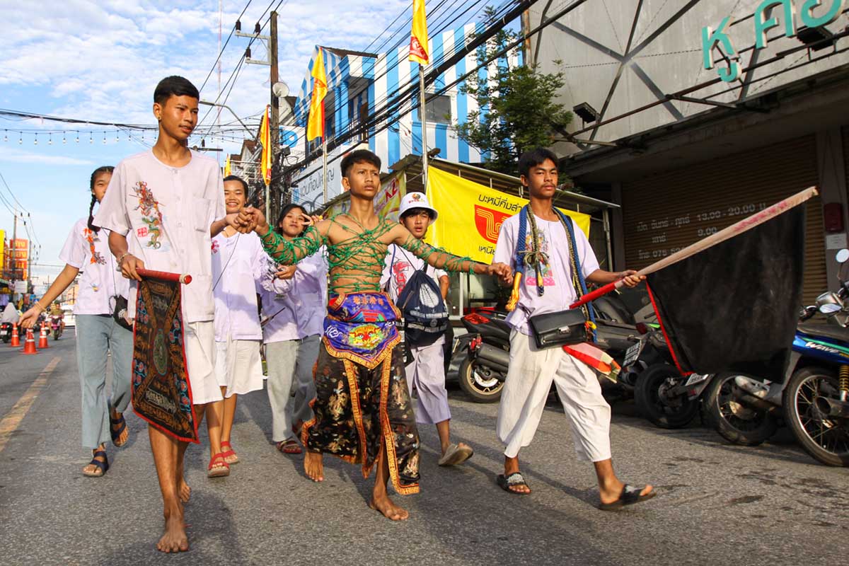 Ma song, a spirit medium at the Phuket Vegetarian Festival, his body wrapped in barbwire, walking in the procession from the Lim Hu Tai Su Shrine, Thailand; photo by Ivan Kralj.