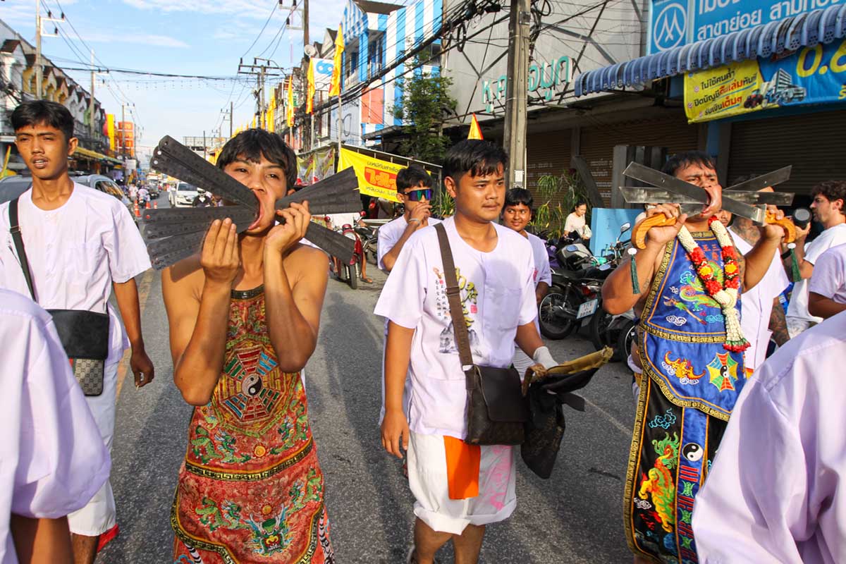 Ma song participants of the Phuket Vegetarian Festival, their faces pierced with rulers and knives, walking in the procession from the Lim Hu Tai Su Shrine, Thailand; photo by Ivan Kralj.