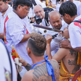 Ma song participant of the Phuket Vegetarian Festival, getting his face cheek pierced by a sword, ahead of the town procession; photo by Ivan Kralj.